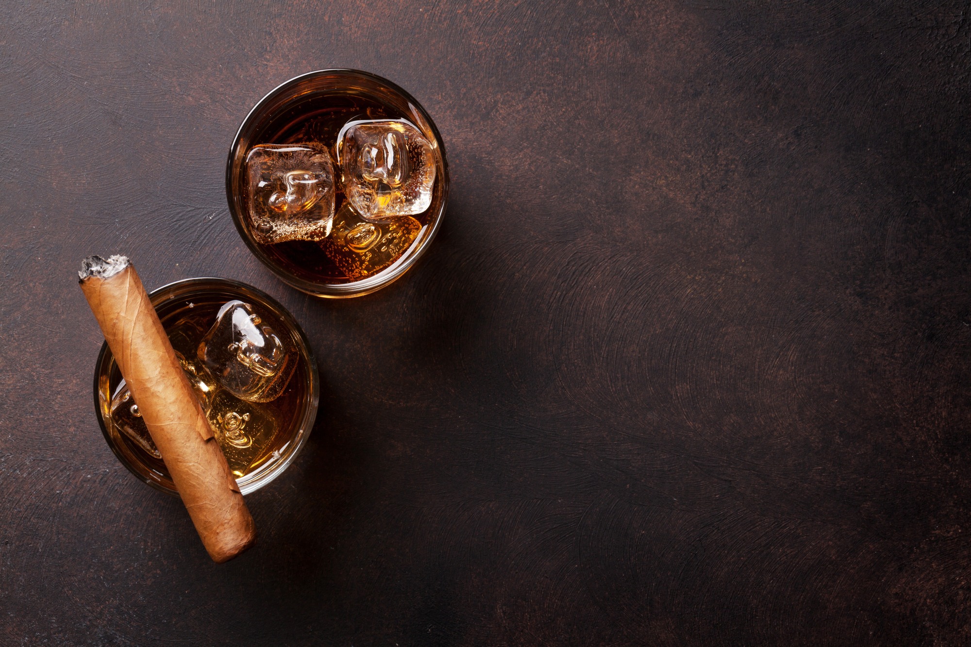 Whiskey with ice and cigar. Top view with copy space